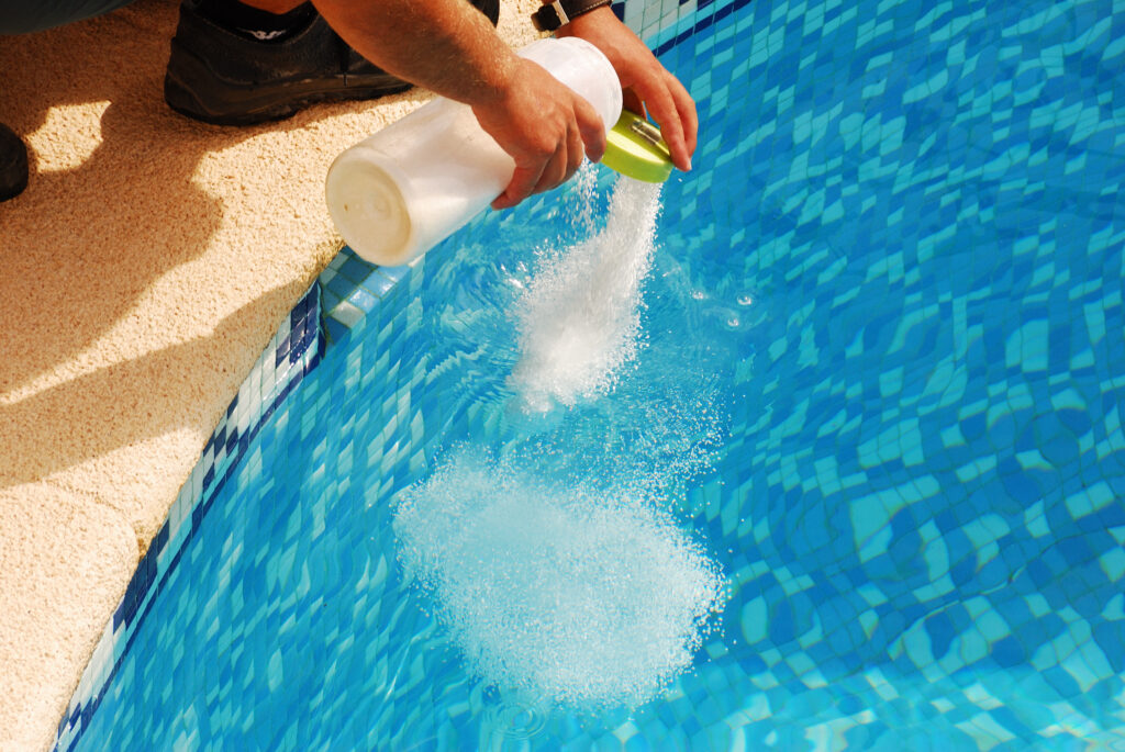 Pool chemicals being added to a pool