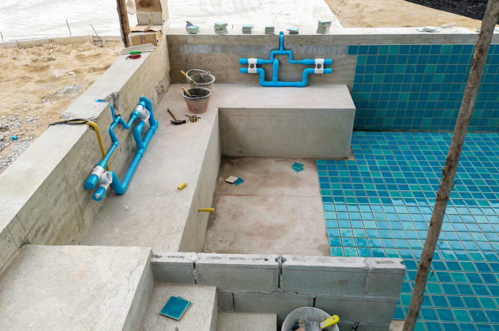 Tiles being installed inside of a pool construct